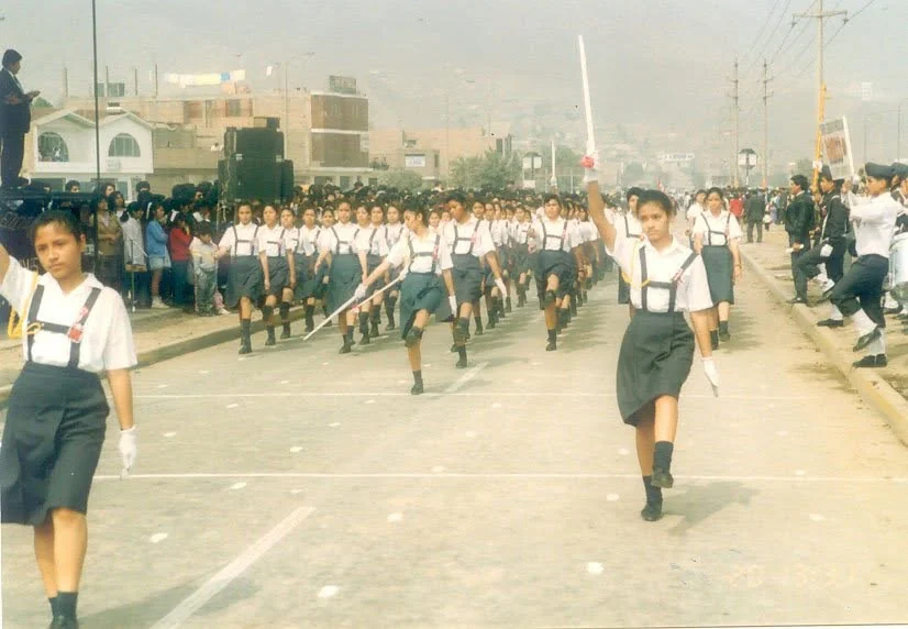 Estudiantes del Colegio Gauss participando en un desfile antiguo