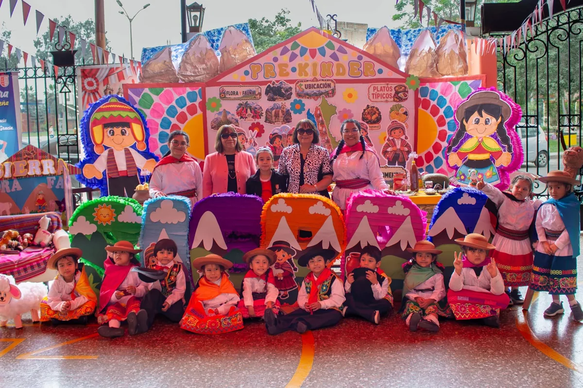 Alumnos pequeños, profesoras y familias en una presentación cultural