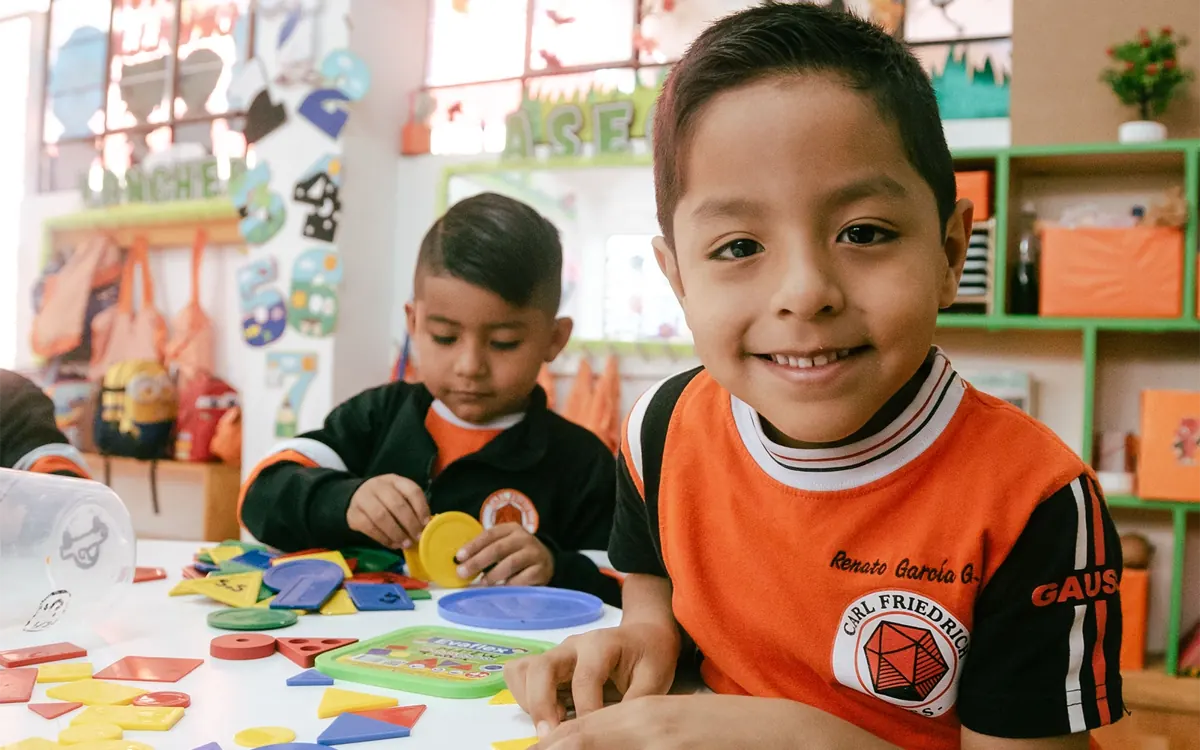 Niños explorando materiales de aprendizaje en el colegio