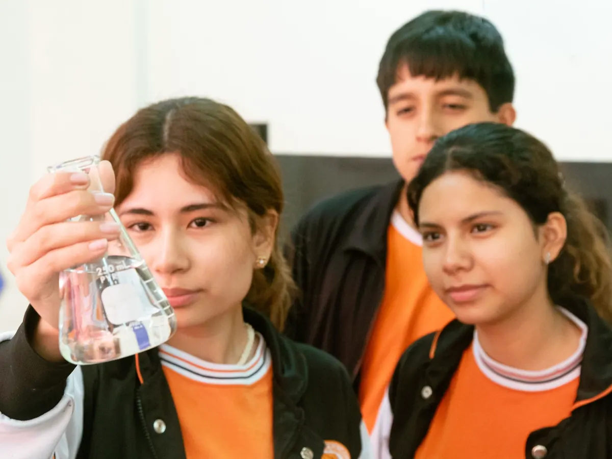 Estudiantes observando un experimento de ciencias