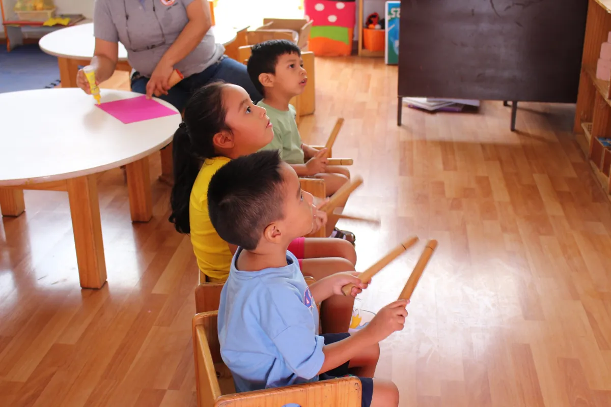 Niños participando con instrumentos de percusión en un taller